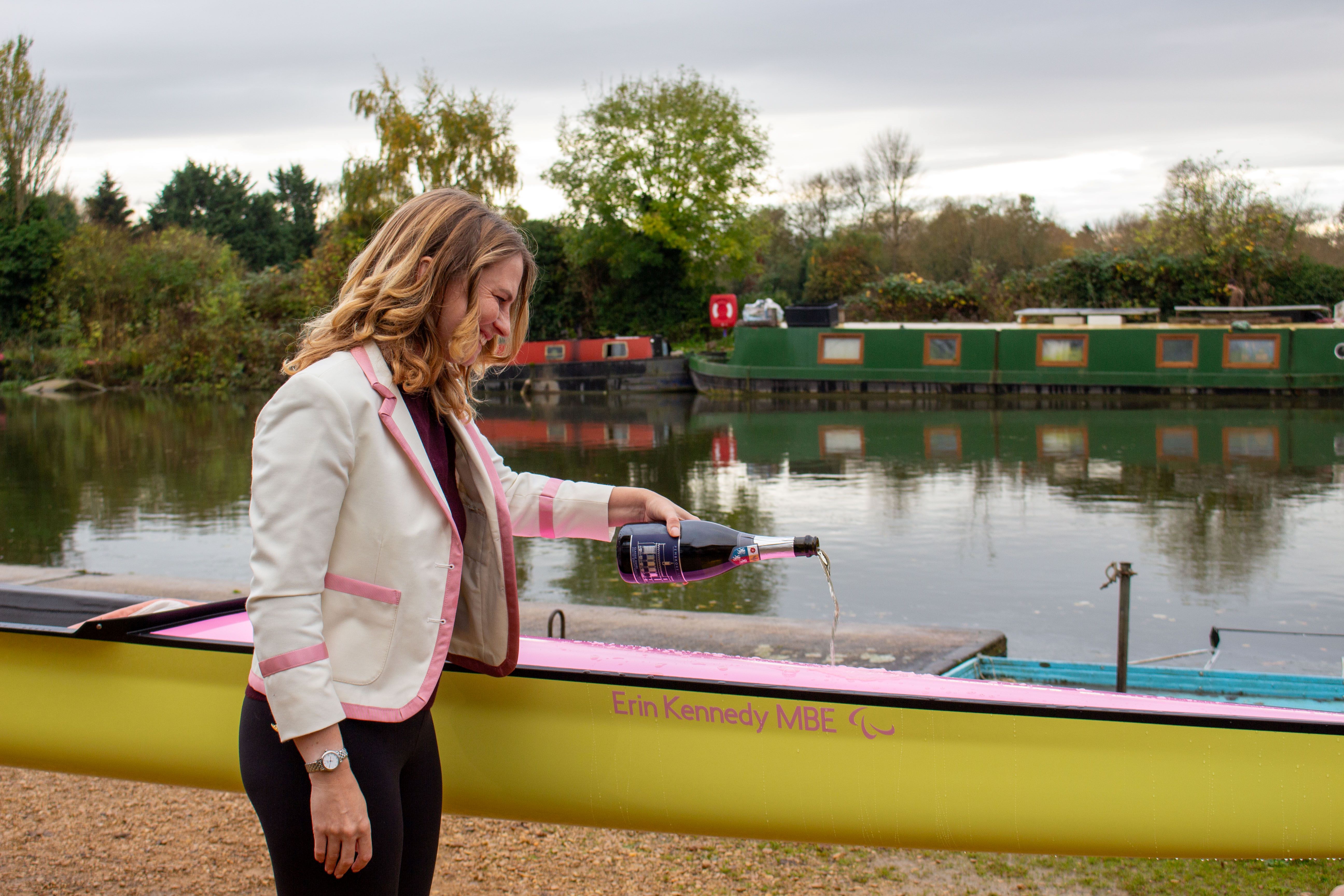 Erin Kennedy pouring champagne over the bow of the new PCBC women's boat.